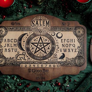 May include: A wooden Ouija board with the word "Salem" and a star symbol in the center. The board features letters, numbers, and the words "Yes," "No," and "Good Bye." The image includes a planchette and lit red candles.