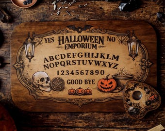 May include: A rectangular wooden spirit board featuring the text Halloween Emporium, the alphabet, numbers zero through nine, and the words Yes, No, and Good Bye. The board includes illustrations of a skull, pumpkins, and lanterns.