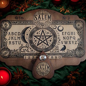 May include: A wooden Ouija board with the word "SALEM" and the text "Witchcraft since 1692". The board features letters, numbers, a crescent moon, a star, a cat, and a raven. A planchette is included.