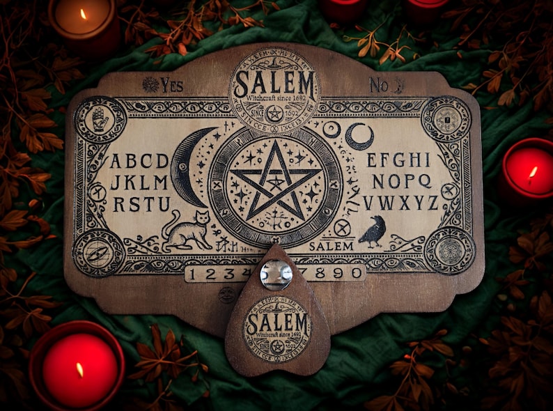 May include: A wooden Ouija board with the word "SALEM" and the text "Witchcraft since 1692". The board features letters, numbers, a crescent moon, a star, a cat, and a raven. A planchette is included.