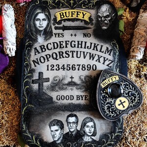 May include: A decorative, rectangular Ouija board with the word "BUFFY" in a banner at the top. The board features portraits, letters, numbers, and the words "YES" and "NO". A heart-shaped planchette is included.