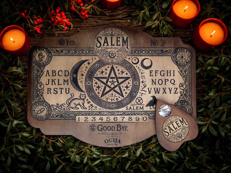 May include: A wooden Ouija board with the word "Salem" and a planchette. The board features letters, numbers, and symbols, including a crescent moon, a star, and a cat. The planchette has the word "Salem" on it. The board is surrounded by candles and greenery.