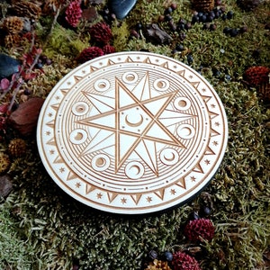 May include: A wooden circle with a carved design of a star with eight points and a crescent moon inside. The star is surrounded by a circle of smaller moons and a circle of stars.
