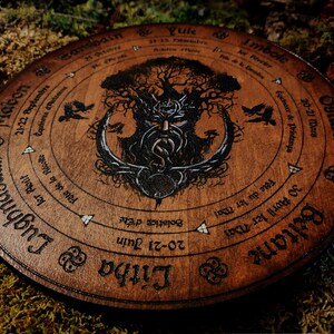 May include: A wooden wheel with a Celtic knot design and a tree of life illustration. The wheel is divided into eight sections, each representing a different season or sabbat. The text on the wheel includes the names of the sabbats in English and the dates they occur.