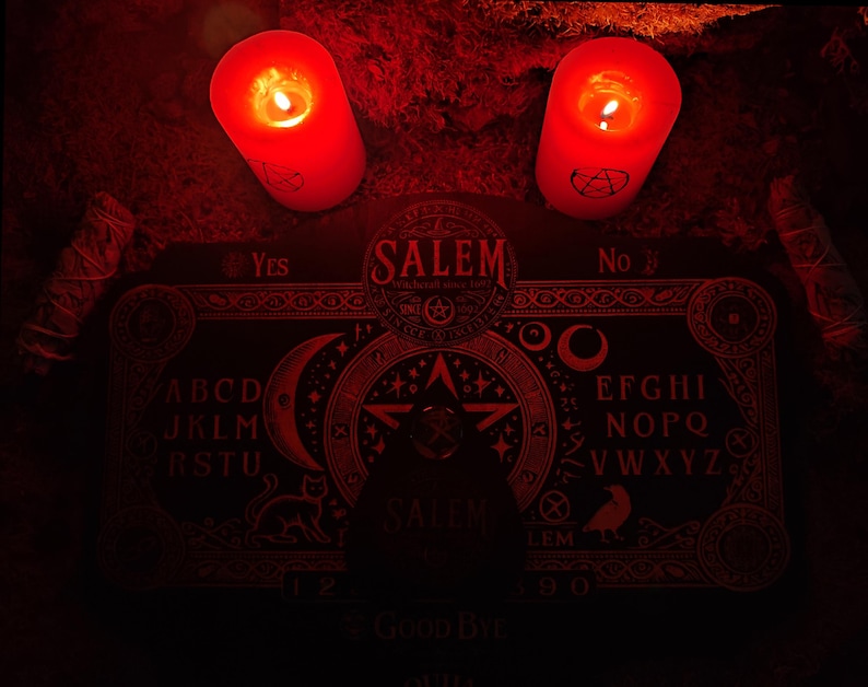May include: A red Ouija board with the word "SALEM" in a circle in the center. The board is surrounded by candles and other occult items.