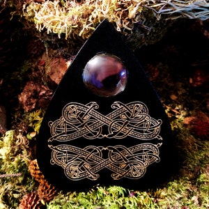May include: Black triangular board with a gold Celtic knot design and a black glass orb in the center.