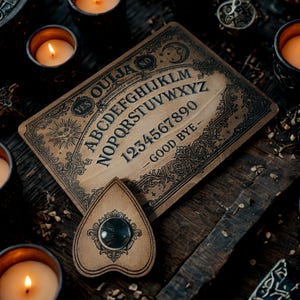 May include: A vintage Ouija board with a planchette, surrounded by lit candles. The board is tan with black lettering and features the alphabet, numbers, and the words "Yes," "No," and "Good Bye." The planchette is heart-shaped with a dark, circular viewing window.