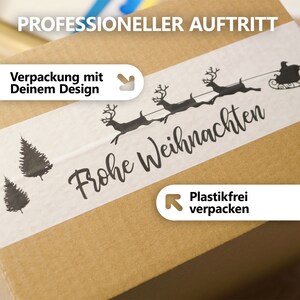 May include: A brown cardboard box with a white strip featuring a black illustration of reindeer pulling a sleigh and the words "Frohe Weihnachten." The box also has text that says "Professional Appearance" and "Packaging with Your Design."