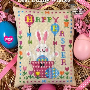 Puede incluir: Un patrón de punto de cruz contado con un conejito sosteniendo huevos de Pascua en una cesta con las palabras "Feliz Pascua" y "Mejores deseos de conejito".