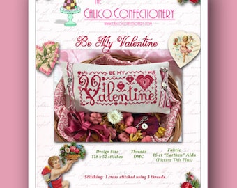 May include: A cross stitch pattern for a Valentine's Day pillow with the text "Be My Valentine" in red lettering on a white background. The pattern is surrounded by a pink and white fabric and a wicker basket filled with dried flowers.