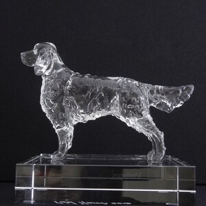 Puede incluir: Una escultura de perro de vidrio transparente sobre una base de vidrio transparente. La escultura es detallada y realista, capturando el pelo y las caracter&iacute;sticas del perro.