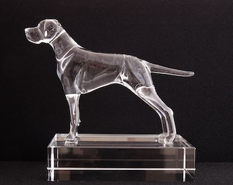 May include: A clear glass sculpture of a dog standing on a clear glass base. The dog is in a running pose with its head turned to the side.