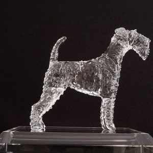 May include: A clear glass sculpture of a dog standing on a clear glass base. The sculpture is detailed with a textured surface.