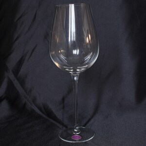 Może przedstawiać: Szklanka do wina z przezroczystego szkła z długą nóżką i szeroką czaszą. Szklanka jest pusta i wygląda na nową.