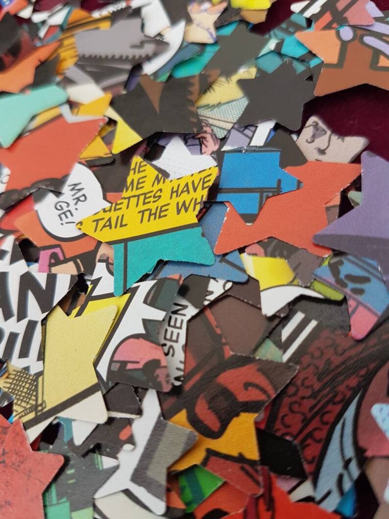 May include: A pile of colourful star-shaped confetti made from recycled comic book pages. The confetti features various images and text, including "Mr. G!" and "Tail the Whiz".