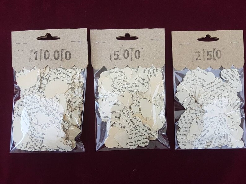May include: Three bags of confetti made from recycled book pages. The bags are labeled 1000, 500, and 250.