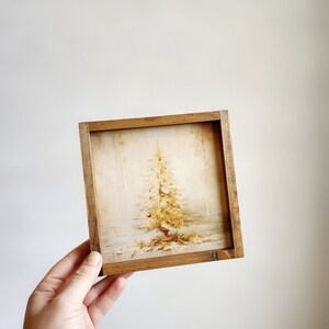 May include: A framed print of a vintage Christmas tree with gold ornaments and a white background.
