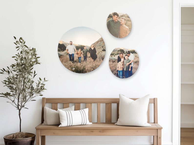 May include: Three round photo prints of a family in a field. The largest print shows a family of five walking in a field. The two smaller prints show a couple with a child.