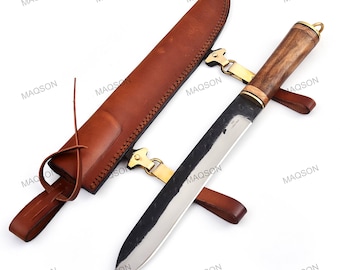 May include: A handcrafted knife with a wooden handle and a stainless steel blade, accompanied by a brown leather sheath. The knife features brass accents and a leather strap for securing the sheath. The blade is approximately 10 inches long.