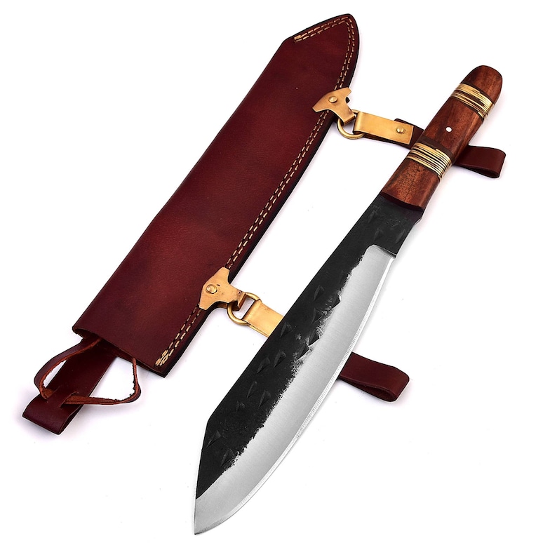 May include: A black and silver knife with a wooden handle and a brown leather sheath. The knife has a curved blade and a brass accent on the handle.