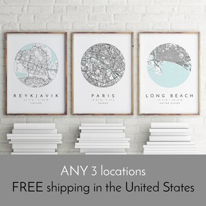 K&ouml;nnte beinhalten: Drei gerahmte Stadtkarten mit hellblauem Hintergrund und schwarzen Linien. Die Karten sind von Reykjavik, Island; Paris, Frankreich; und Long Beach, Kalifornien. Der Text "ANY 3 locations" und "FREE shipping in the United States" befindet sich unter den Bildern.