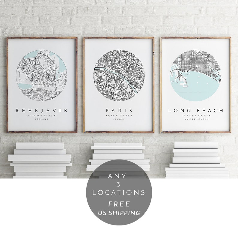 K&ouml;nnte beinhalten: Drei gerahmte Stadtkarten mit hellblauem Hintergrund und schwarzen Linien. Die Karten sind von Reykjavik, Island; Paris, Frankreich; und Long Beach, Kalifornien. Der Text "ANY 3 LOCATIONS FREE US SHIPPING" befindet sich in einem Kreis unter den Karten.