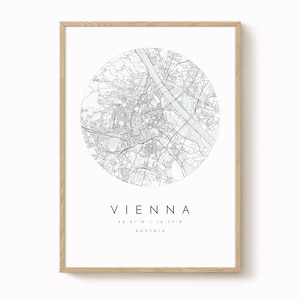 Può includere: Una stampa incorniciata con una mappa dettagliata di Vienna, Austria, in un design circolare. La mappa è in bianco e nero, con il nome della città e le coordinate sottostanti. La cornice è in legno chiaro.