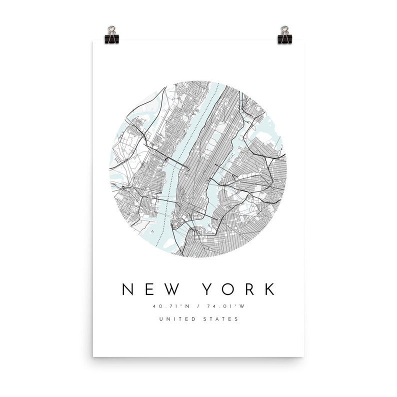 May include: A black and white map of New York City in a circle with a light blue background. The text "NEW YORK" is below the map, along with the coordinates "40.71&deg;N / 74.01&deg;W" and "UNITED STATES".