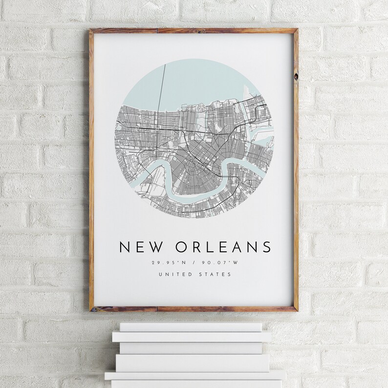 K&ouml;nnte beinhalten: Ein gerahmter Druck einer Karte von New Orleans, Louisiana, mit hellblauem Hintergrund und grauen Linien, die die Stra&szlig;en darstellen. Der Name der Stadt und die Koordinaten sind unter der Karte gedruckt. Der Text lautet "New Orleans 29.95&deg;N / 90.07&deg;W VEREINIGTE STAATEN".