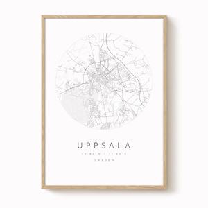 May include: A framed print featuring a detailed black and white map of Uppsala, Sweden, set within a circular design. The city name and coordinates are displayed below the map. The frame is a light wood color.
