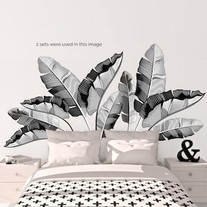 May include: Black and white banana leaf wall decals. The image shows a bedroom with a bed, nightstands, and decorative elements. The text in the image says "2 sets were used in this image".