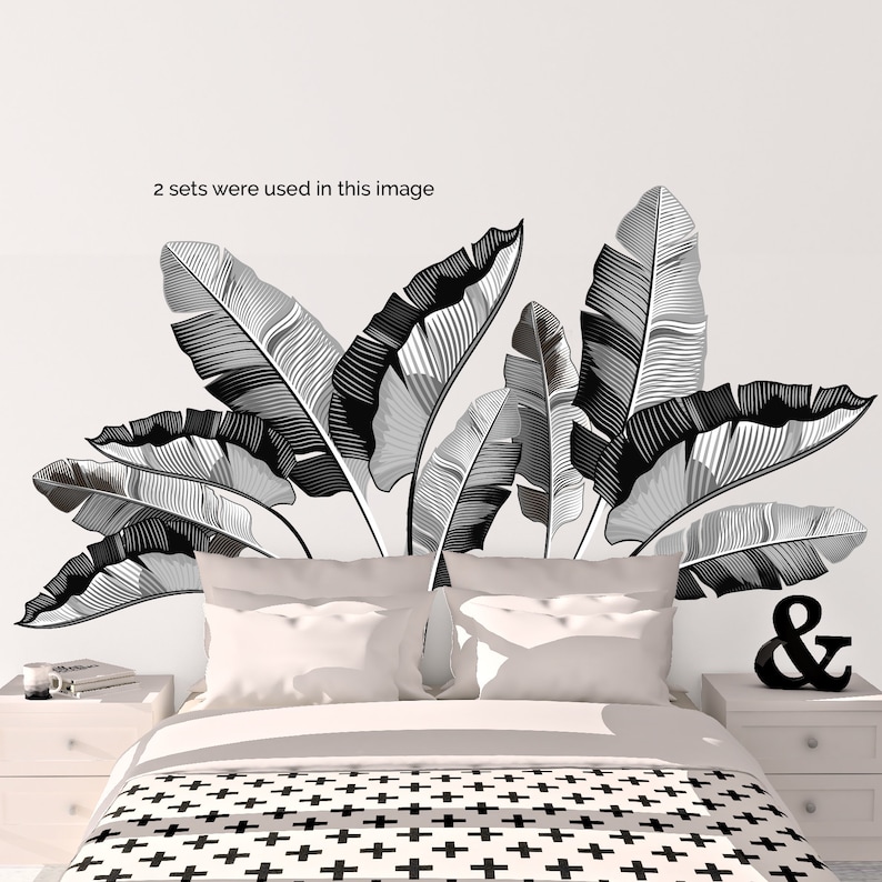 May include: Black and white banana leaf wall decals. The image shows a bedroom with a bed, nightstands, and decorative elements. The text in the image says "2 sets were used in this image".