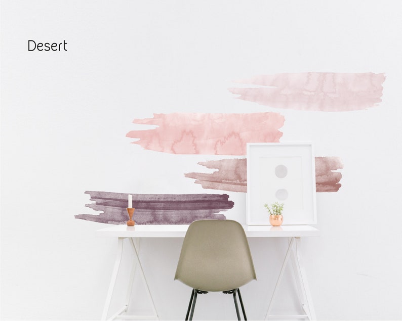 May include: A white desk with a white chair and a framed picture. The wall behind the desk has a pink and brown watercolor design with the word "Desert" written in black at the top.