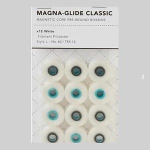 May include: A package of twelve white Magna-Glide Classic magnetic core pre-wound bobbins. The package includes the text "MAGNA-GLIDE CLASSIC" and "MAGNETIC CORE PRE-WOUND BOBBINS". The bobbins are made of filament polyester, style L, No. 60/TEX 12.