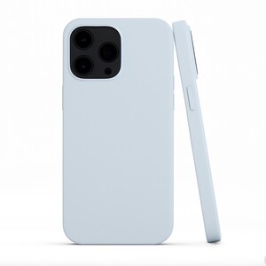 May include: Two light blue phone cases. One case is upright, showcasing the camera cutouts. The other case is leaning against the first, displaying the side buttons. The cases have a smooth, matte finish.