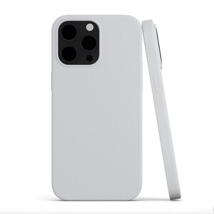 May include: Two white phone cases, one upright and one leaning. The upright case shows the camera cutouts. The cases are a solid, matte white color. The phone cases are designed to protect the phone.