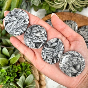 May include: Four smooth, round, white and black patterned stones. The stones have a unique, swirling, marbled pattern.