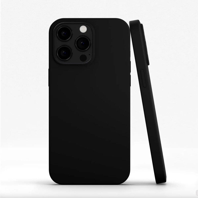 May include: A black phone case, shown upright and leaning against another. The case has a matte finish and features cutouts for the camera lenses and flash. The phone case is designed to protect the phone from scratches and damage.