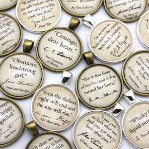 May include: A collection of round, bronze-colored pendants with inspirational quotes and author names. The quotes include "Courage, dear heart." by C.S. Lewis, "Obstinate, headstrong girl." by Jane Austen, "Even the darkest night will end and the sun will rise." by Victor Hugo, "I got you to look after me, and you got me to look after you." by John Steinbeck, "She is too fond of books, and it has turned her brain." by Jane Austen, "So we beat on, boats against the current, borne back ceaselessly into the past." by F. Scott Fitzgerald, "We'll be friends forever, won't we, Pooh?" by A.A. Milne, "Friendship is love without his wings." by  J.M. Barrie, "Education never ends, Watson. It is a series of lessons, with the greatest for the last." by Arthur Conan Doyle, "Whisky is liquid sunshine." by J.R.R. Tolkien.