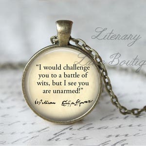 May include: A bronze necklace with a round glass pendant featuring a quote by William Shakespeare: "I would challenge you to a battle of wits, but I see you are unarmed!" The pendant is on a chain with a bronze clasp.