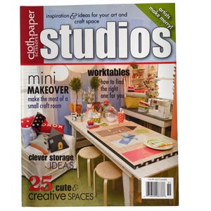 May include: A magazine cover titled "studios" with the text "inspiration & ideas for your art and craft space." The cover features a craft room scene with a table, sewing machine, and the text "mini makeover" and "25 cute & creative spaces."