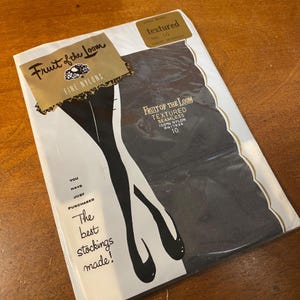 Könnte beinhalten: Eine Packung Fruit of the Loom strukturierter, nahtloser Nylonstrümpfe in Größe 10, Farbe Mitternacht. Die Verpackung zeigt das Fruit of the Loom-Logo und den Text "Die besten Strümpfe hergestellt!"