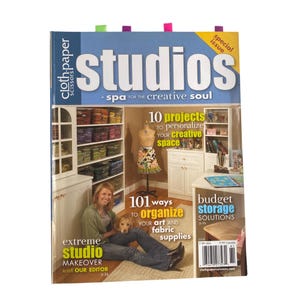 May include: A magazine cover titled "studios" with the text "A spa for the creative soul." The cover features a woman with a dog, a mannequin, and text about organizing art supplies and creative spaces.