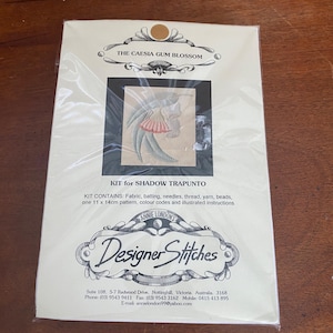Pode incluir: Um kit de bordado shadow trapunto com o texto "The Caesia Gum Blossom" e "Designer Stitches". O kit inclui tecido, enchimento, agulhas, linha, fio, contas, um padrão (11 x 14 cm), códigos de cores e instruções.