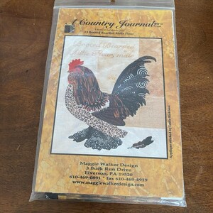 May include: A Country Journal quilt pattern packet featuring a rooster design. The packet includes the text "Booted Bearded Mille Fleur, male" and the Maggie Walker Design address. The rooster has a red comb, brown and black feathers, and a patterned tail.