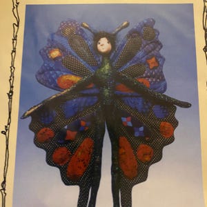 May include: A whimsical butterfly figure with outstretched arms, featuring blue wings with orange and red accents. The butterfly has a human-like face and a green body, set against a light blue background.