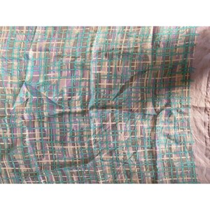 May include: A light pink and blue patterned fabric with a grid design. The fabric is sheer and has a soft, flowing texture.