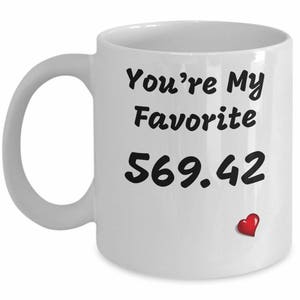 May include: White ceramic mug with black text that reads "You're My Favorite 569.42" with a small red heart.