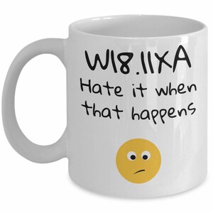 May include: White ceramic coffee mug with black text that reads "WIB.IIXA Hate it when that happens" and a yellow emoji with a confused expression.
