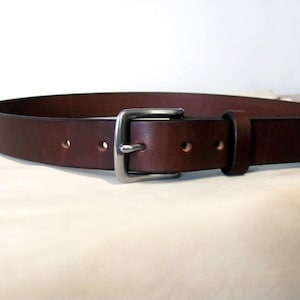 May include: A brown leather belt with a silver buckle.